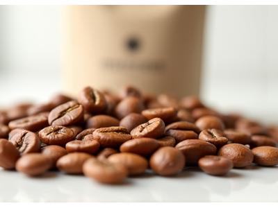 Lightly roasted Ethiopian Yirgacheffe coffee beans displayed next to a bag, emphasizing their brighter, fruiter appearance.